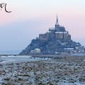 Mont Saint-Michel sous la neige au soleil levant.