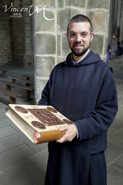 Frère Charles-Marie portant la nouvelle bible du Mont Saint-Michel.
